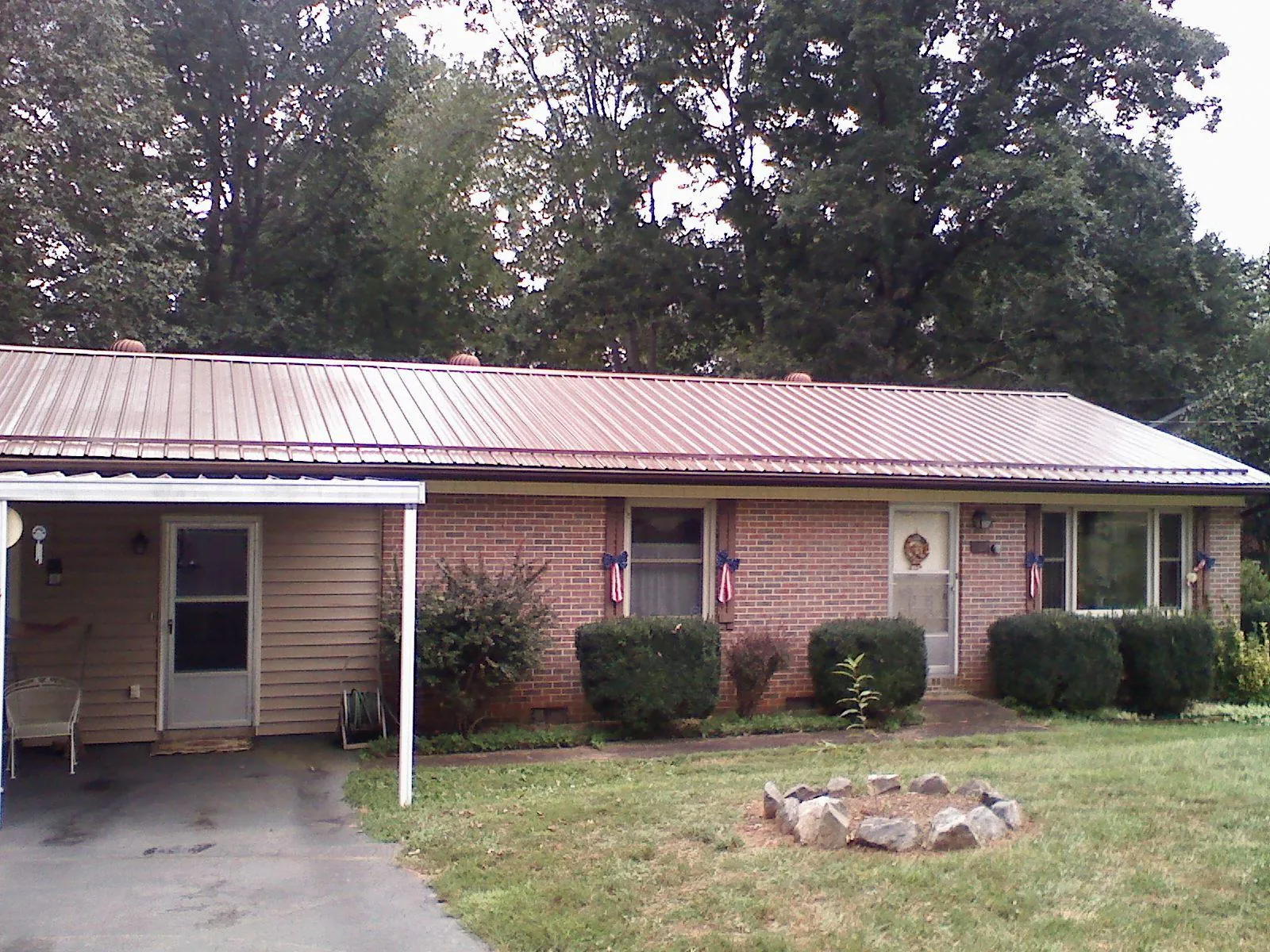 Bronze metal roof and carport on a brick ranch home — Roof Repair work by our crew in New Troy